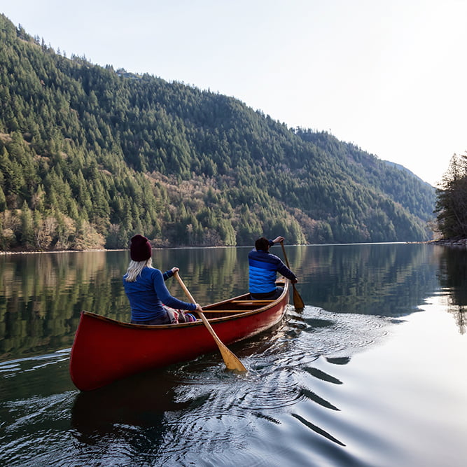 Couple,Friends,Canoeing,On,A,Wooden,Canoe,During,A,Sunny